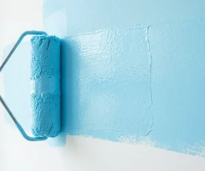 Does paint dry darker or lighter, blue paint roller applying wet latex paint on white wall