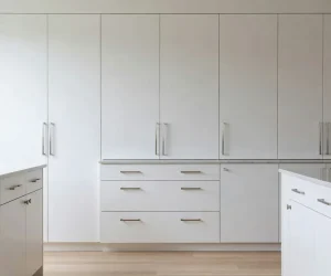 How to paint kitchen cabinets — freshly painted white kitchen cabinets with modern silver hardware and clean satin finish
