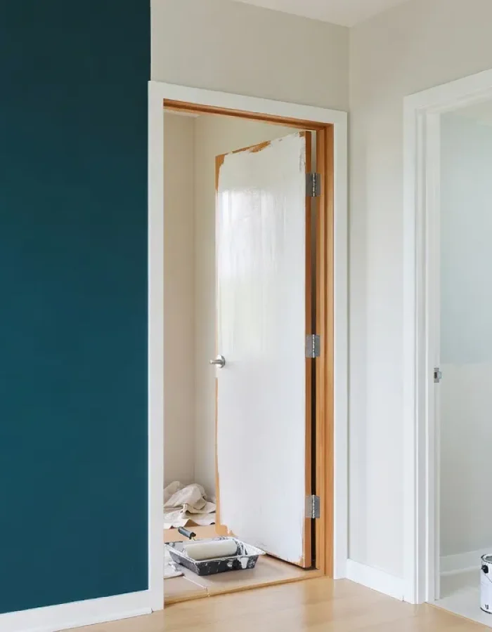 A teal accent wall, a door mid-coat, and a bathroom paint can in the background, showing real quart of paint coverage across different small projects.