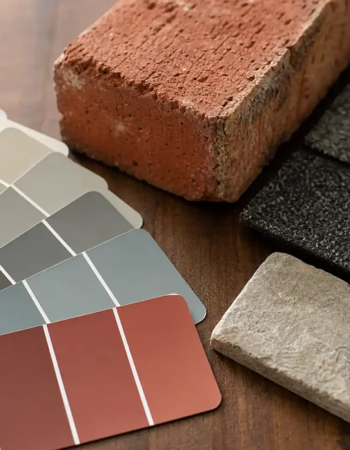Before picking a paint color, hold your options next to your brick, roof, and stone to see what actually works together.