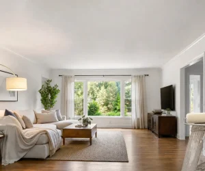 Bright living room with a smooth white ceiling, showing what sheen for ceiling paint works best, with a paint roller and can on a ladder